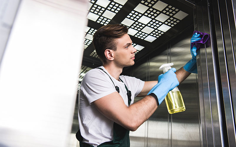 Eine Person reinigt den Aufzug